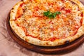 Italian Pizza Margherita with tomatoes and mozzarella cheese on wooden cutting board. Royalty Free Stock Photo