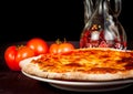 Italian pizza near tomatoes and spicy oil, typical italian pizza Royalty Free Stock Photo