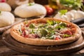 Italian Pizza with rocket salad on wooden table