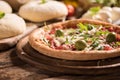 Italian Pizza with rocket salad on wooden table