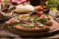 Italian Pizza with rocket salad on wooden table