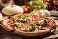 Italian Pizza with rocket salad on wooden table