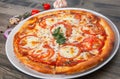 Italian pizza with tomato topped with melted golden cheese, herbs and basil