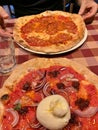 Italian pizzeria, pizzas in two flavors on the table, pizza with bufala mozzarella, pizza with schiacciata salami, classic Italian