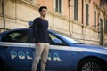 Italian policeman standing alongside a patrol car