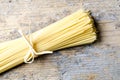 Italian raw pasta on rustic wooden table from above. Traditional long spaghetti dry