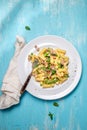 Italian recipe Pasta tortilloni with green pea, mint leaves, cheece, smoked bacon and cheese. Top view, blue background.