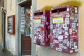 Italian red mail boxes of the italian mail service full of stickers near to a souvenir store in front of the world famous monument