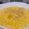 Italian risotto with pumpkin, rosemary, biscuits in a white plate, close-up. Royalty Free Stock Photo