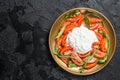 Italian salad caprese with cheese stracciatella, tomatoes and arugula. Black background. Top view. Copy space Royalty Free Stock Photo