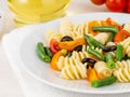 Italian salad with fusilli paste tomatoes, olives, green beans, part of, side view, close up Royalty Free Stock Photo