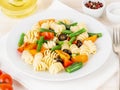 Italian salad with fusilli paste tomatoes, olives, green beans, side view, close up Royalty Free Stock Photo