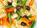 Italian salad with fusilli paste tomatoes, olives, green beans, top view, close up Royalty Free Stock Photo