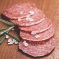 Italian salami sausage slices with rosemary and sea salt Royalty Free Stock Photo