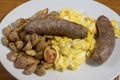 italian sauage on scramble eggs served with home fries