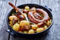 Italian sausage roasted with new potato on a dish