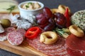Italian sausages sliced on a meat board with pate, pepper and traditional taralli biscuits - the concept of a snack for red wine Royalty Free Stock Photo