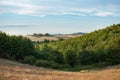 Italian scenery with golden filds, forest and sky. Idyllic summer landscape in Tuscany, Italy, Europe