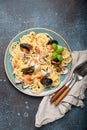 Italian seafood pasta spaghetti with mussels, shrimps, clams in tomato sauce with green basil on plate on rustic blue Royalty Free Stock Photo