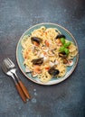 Italian seafood pasta spaghetti with mussels, shrimps, clams in tomato sauce with green basil on plate on rustic blue Royalty Free Stock Photo