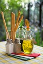 Italian serving table set of olive oil, bread sticks, salt, pepper. Vertical