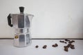 An Italian silver coffee filters with coffee beans . On white background