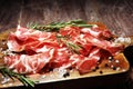 Italian sliced cured coppa with spices. Raw ham. Crudo or jamon with rosemary Royalty Free Stock Photo