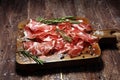 Italian sliced cured coppa with spices. Raw ham. Crudo or jamon with rosemary Royalty Free Stock Photo