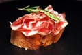 Italian sliced cured coppa with spices. Raw ham. Crudo or jamon with rosemary Royalty Free Stock Photo