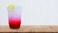 Italian soda made from fruit syrup drink mix in plastic cup on wooden table. Lemon, Red cocktail summer refreshment drink, Summer Royalty Free Stock Photo