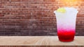 Italian soda made from fruit syrup drink mix in plastic cup on wooden table. Lemon, Red cocktail summer refreshment drink, Summer Royalty Free Stock Photo