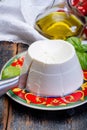 Italian soft cheese, young white ricotta cheese served with fresh basil and tasty ripe cherry tomatoes Royalty Free Stock Photo