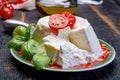 Italian soft cheese, young white ricotta cheese served with fresh basil and tasty ripe cherry tomatoes Royalty Free Stock Photo