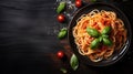 Italian spaghetti pasta with basil garnish and herbs on black wooden board background, text copy space, top down view Royalty Free Stock Photo