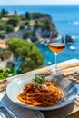 Italian spaghetti Bolognese featuring mincemeat and tomato sauce and Parmesan cheese, with a glass of wine, set against a Royalty Free Stock Photo