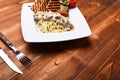 Italian spaghetti with chicken and mushrooms on square plate Royalty Free Stock Photo