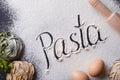 Italian spaghetti ingridients on a black background with bottle of oil and rolling pin. Word Pasta written on the flour. Royalty Free Stock Photo