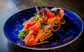 Italian spaghetti pasta marinara with Clams, Prawns, Mussels, tomato, Seafood Cocktail in blue plate on wooden table