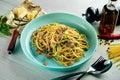 Italian spaghetti pasta with white sauce, beef, vegetables and parmesan cheese served in a blue plate on a wooden background. Royalty Free Stock Photo