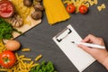 Italian spaghetti photo recipe. Hand with pen writting on blank Royalty Free Stock Photo