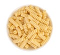 Italian spiral shaped pasta, Fusilli bucati macaroni in ceramic bowl, isolated on white background. Top view. Flat lay. Royalty Free Stock Photo