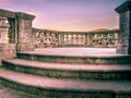 Italian stone balustrade illuminated by sun rays and water in the background Royalty Free Stock Photo