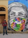 Italian street art graffiti mural woman face in medical mask. Stornara, Puglia, Italy