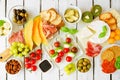 Italian charcuterie table scene against a white wood background. Overhead view.