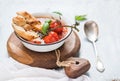 Italian tomato, garlic and basil soup Pappa al Pomodoro in metal bowl with bread on rustic wooden board over light blue Royalty Free Stock Photo