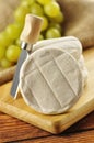 Italian tomino cheese on a wooden chopping board Royalty Free Stock Photo