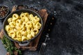Italian tortellini pasta with cheese sauce in a pan. Black background. Top view. Copy space Royalty Free Stock Photo