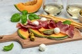 Italian traditional appetizer Prosciutto con Melone, mozzarelle and basilico. Cantaloupe melon with prosciutto or jamon, Royalty Free Stock Photo