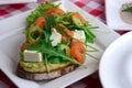 Italian traditional bruschetta with tomato basil and green olives. Served on a white plate over red plaid tablecloth. Royalty Free Stock Photo