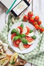 Italian traditional Caprese salad with traveler smartphone map t